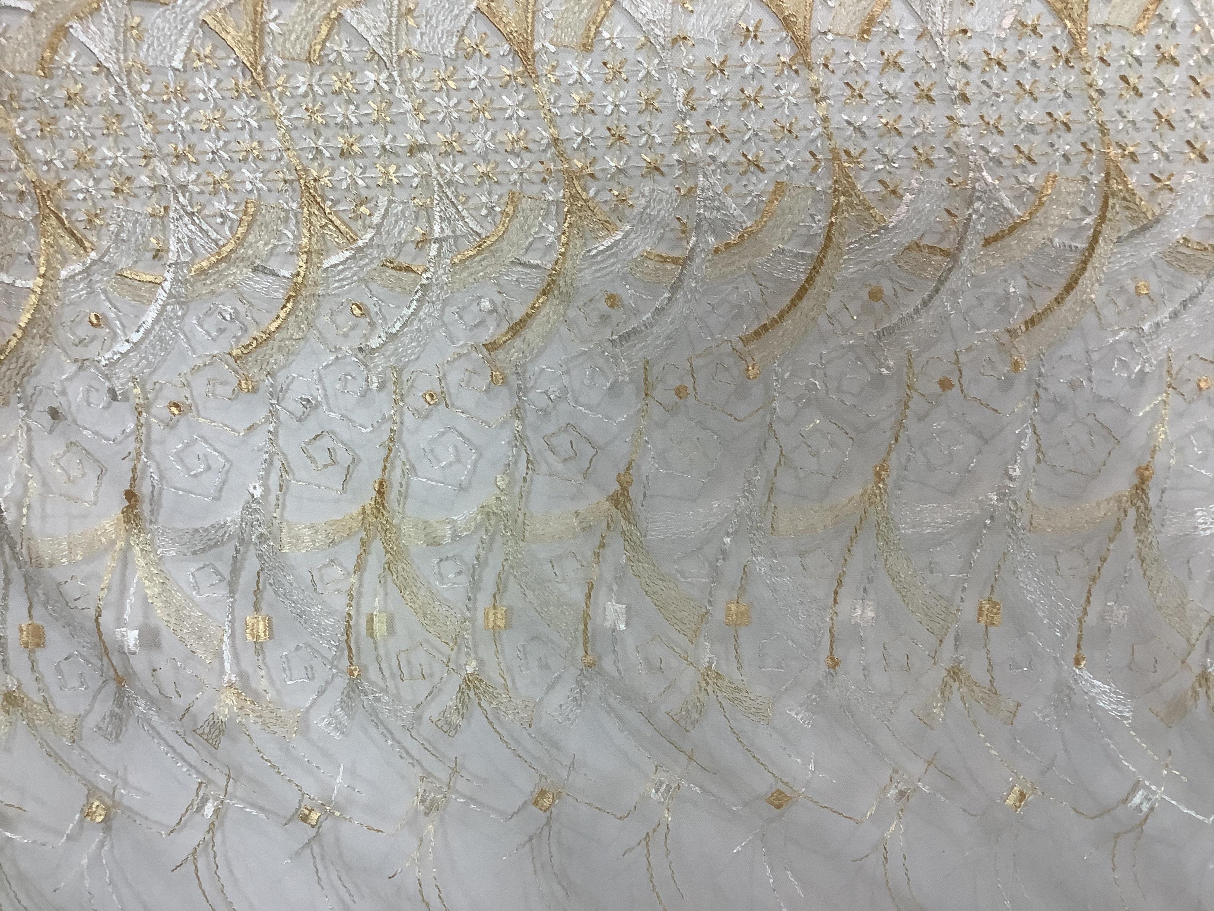 A French Art Deco wide silk yellow and cream embroidered net curtain, bordered at the bottom with yellow silk fringing. Approximately 560cm wide x 170cm long (not including fringing)., Condition - the curtain may need re